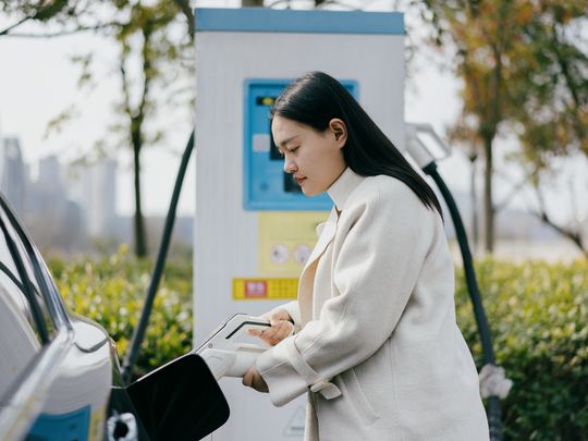 一名女子正在给电动汽车充电