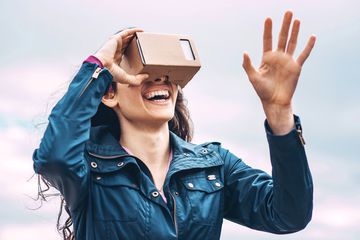 一名女子戴着谷歌Cardboard VR头显，正在使用虚拟现实iPhone应用程序。