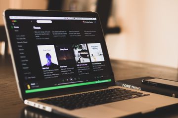 电脑坐在桌子上展示Spotify